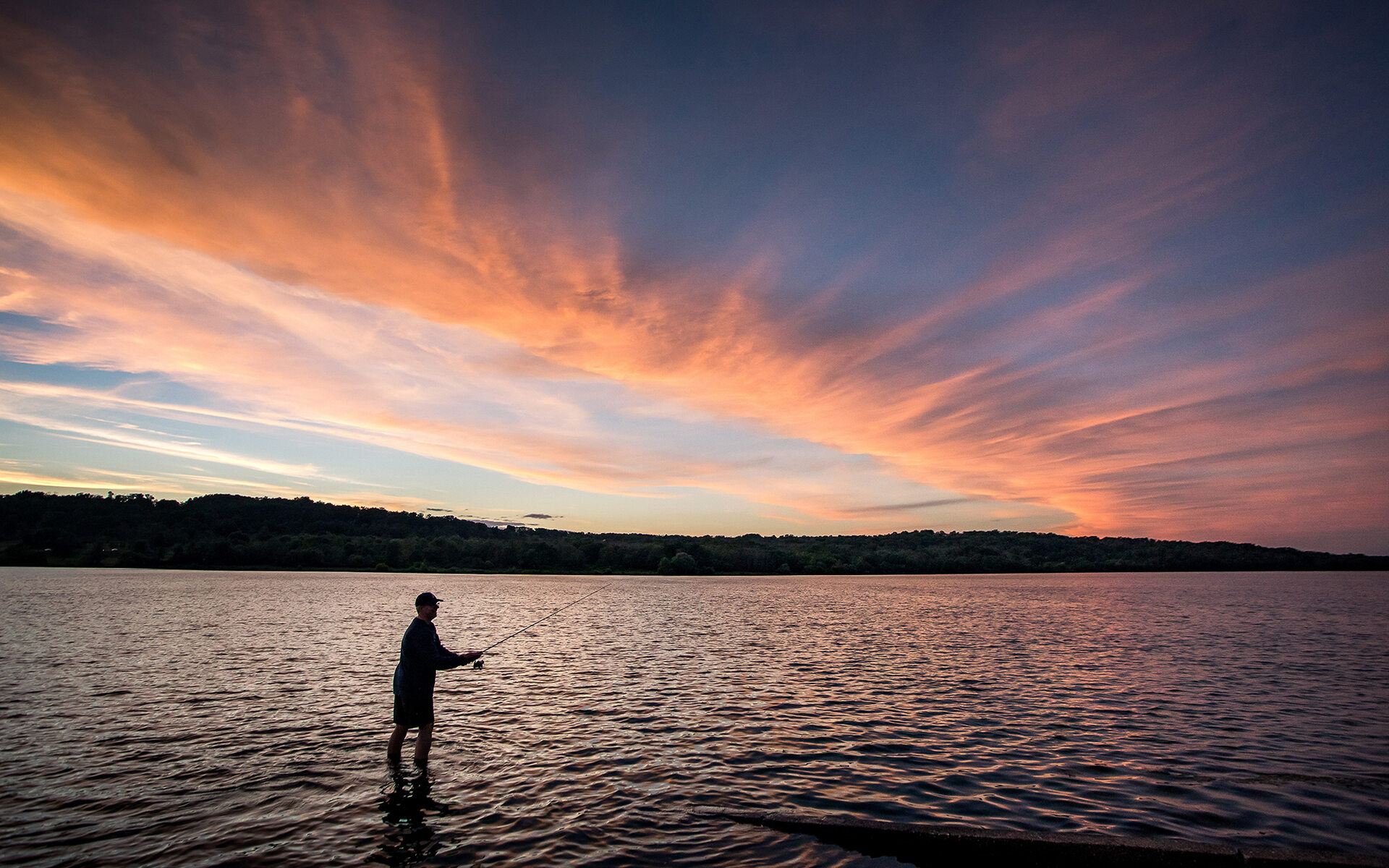 A serene view of Lake Galena in Bucks County, PA, showcasing calm waters surrounded by lush greenery and trees.